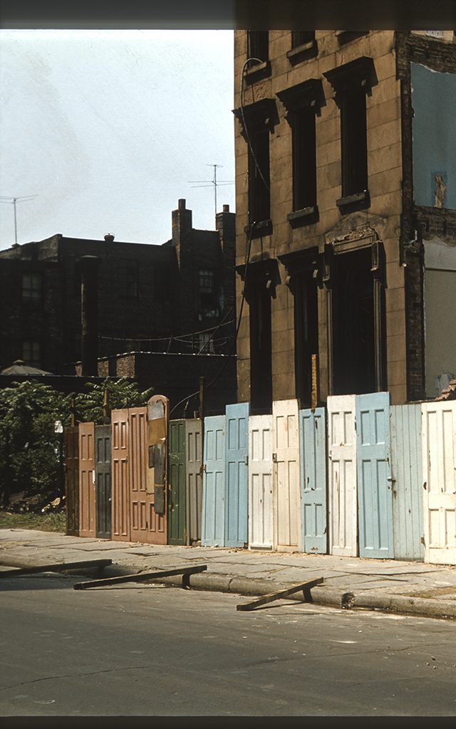 A block of Brooklyn, NY walled off with doors in different colors.