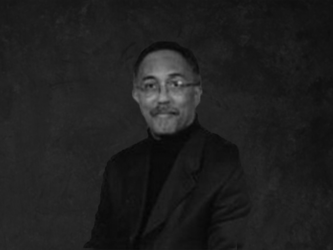 Larry smiling in front of a grayscale photo backdrop