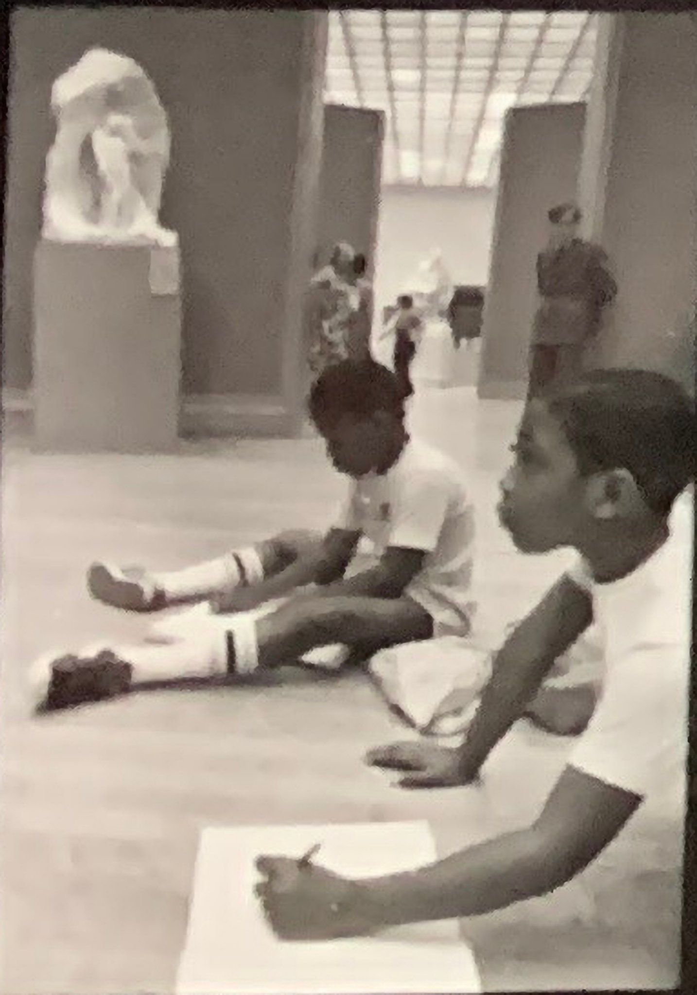 Two students seated on the floor sketching sculptures at the Metropolitan Museum of Art