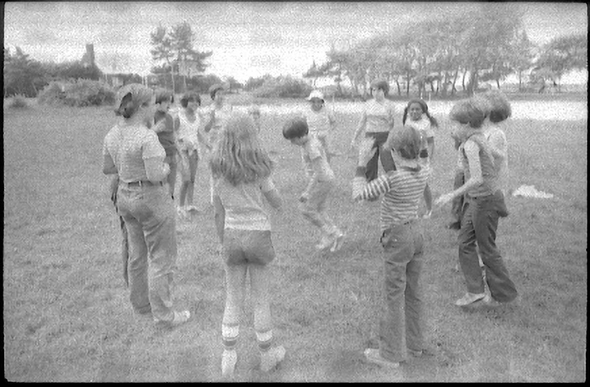 Students assembled in a circle. In the center, another student appears to be dancing.