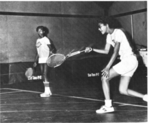 Two students playing badminton
