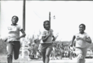Three students running on a track