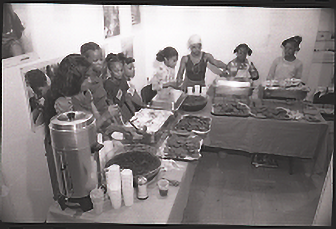 Students standing in from of trays of food.