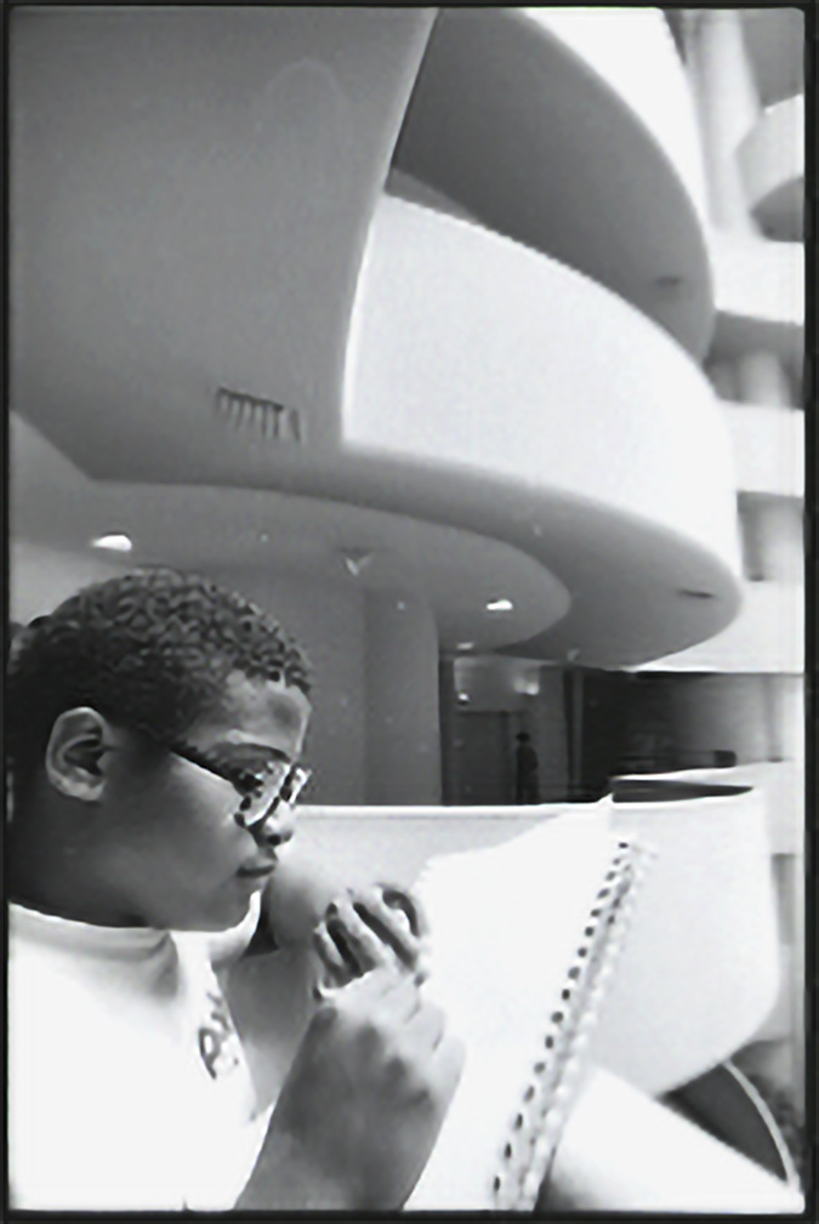 A student writing in a notebook inside the Guggenheim
