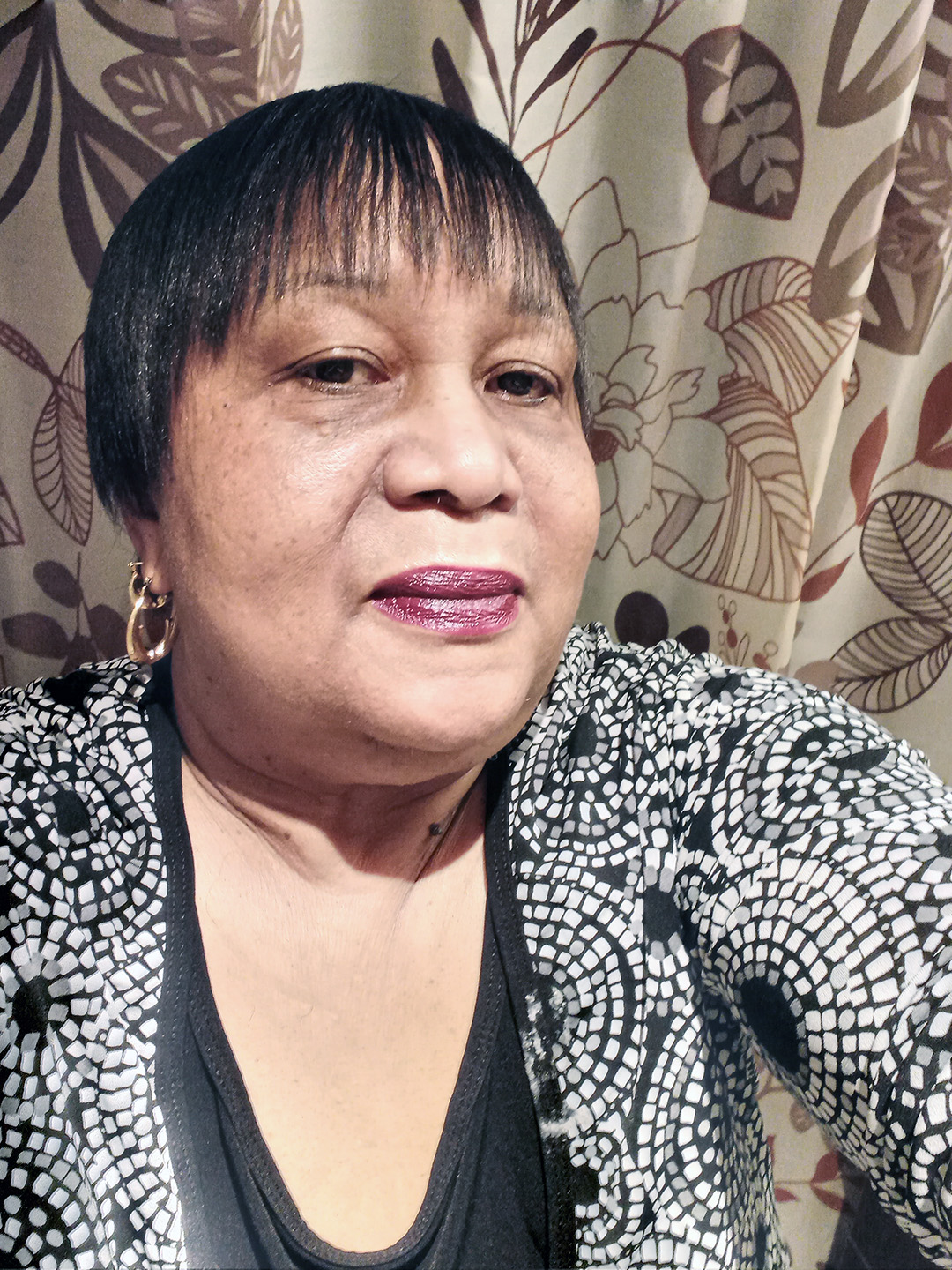 Valerie Glasgow smiling at the camera. She is wearing a black & white blouse.